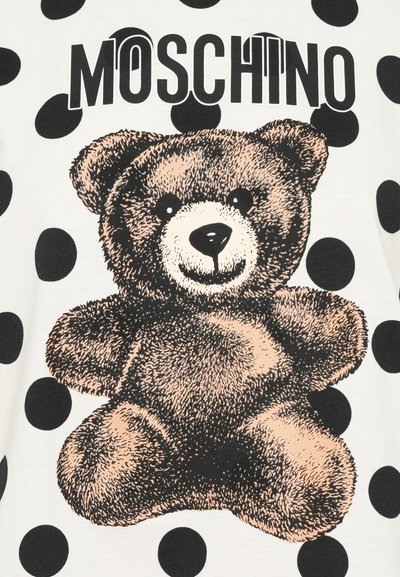 Moschino t-shirt featuring a brown teddy bear graphic, black polka dots on a white background, with bold black lettering above the bear.