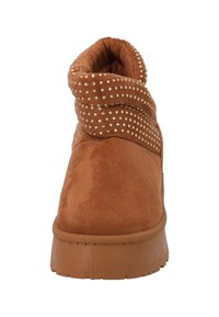 Bruine enkellaars van synthetisch suède met een omslagkraag versierd met gouden studs, voorzien van een gestructureerde rubberen zool en een gevoerde binnenkant.