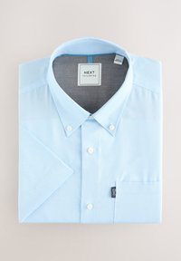 Jasnoniebieska dopasowana koszula z kołnierzykiem na guziki, krótkimi rękawami i kieszenią na piersi. Posiada metkę z logo po boku oraz gładką strukturę materiału.