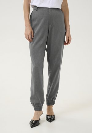 Pantaloni tapered grigi con vita elastica e caviglie con risvolto, caratterizzati da una sottile texture e un fit liscio e su misura. Abbinati a tacchi neri.