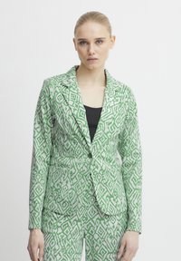 Green and white patterned blazer with a structured design, featuring a notch lapel, two front pockets, and a single button closure.