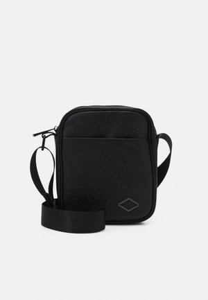 Sac bandoulière compact noir avec bandoulière ajustable, texte en relief répété et poche avant avec petite étiquette logo en forme de diamant.