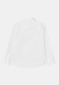 Camicia bianca a maniche lunghe con colletto appuntito, polsini con bottoni e una texture liscia. Presenta una cucitura a yoke sul retro e un orlo curvo.