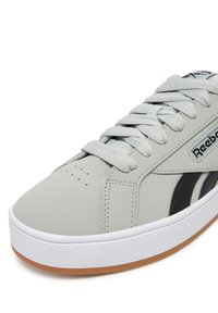 Szare skórzane sneakersy z czarnymi akcentami i logo. Posiadają płaskie sznurówki, zaokrąglony czubek oraz białą gumową podeszwę z podeszwa z gumy.