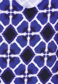 Blå och vit mönstrad tyg med ett symmetriskt diamantdesign och mjuka texturer. Mönstret inkluderar olika nyanser av blått.