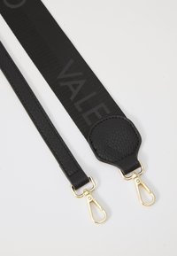 Cintura nera regolabile con una sezione in pelle texturizzata, clip dorati e la parola "VALE" stampata con un finish opaco su tessuto.