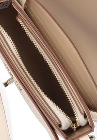 Borsa beige con zip dorate, caratterizzata da tre scomparti. Esterno in pelle liscia e dettagli in metallo color oro.