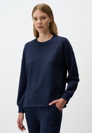 Marineblauwe sweatshirt gemaakt van zachte stof, met een ronde hals, lange mouwen en een losse pasvorm met ribgebreide manchetten.