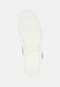 Suola in gomma bianca con scanalature orizzontali, marchiata con "GUESS" al centro, che presenta un design semplice e texturizzato.