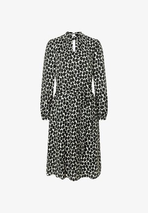 Zwart-wit stippenjurk met lange mouwen, sleutelgat halslijn, getailleerde taille en een gestrikt riem in de taille. Zachte stoffen textuur.