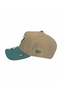 Baseballcap mit einem sandfarbenen Körper, grünem Schirm und gesticktem Logo. Besitzt eine strukturierte Form und einen verstellbaren Snapback-Verschluss.