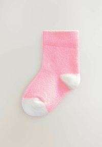 Pink cotton sock with a ribbed texture and white toe and heel accents, featuring a standard crew height design.