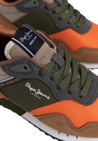 Sneakers Pepe Jeans con una combinazione di mesh arancione, suede verde oliva e tan. Dotati di lingua imbottita, lacci testurizzati e logo sul lato.
