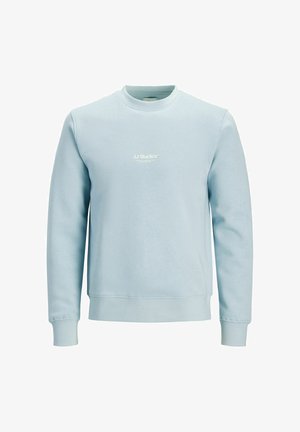 Svetlomodrá mikina s okrúhlym výstrihom vyrobená z mäkkej látky. Má rebrované manžety a lem, na prednej strane je vytlačené biele logo „JJ Studios“.