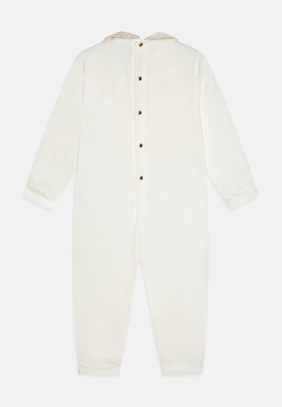 Bílý overal z měkké tkaniny, s kapucí, dlouhými rukávy a knoflíkovým zapínáním na zádech. Rukávy jsou mírně přiléhavé.
