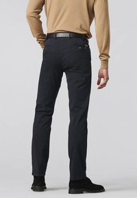 Pantalons en coton extensible bleu marine avec une coupe slim, dotés de deux poches arrière et d'une ceinture. Texture lisse et design simple.