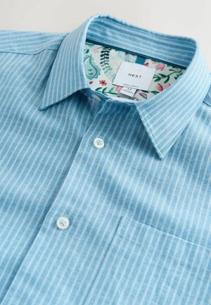 Lyseblå stribet skjorte med almindelig pasform. Har en button-down-krave, hvide knapper og et blomsterprintet inderfor.