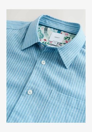 Lyseblå stribet skjorte med almindelig pasform. Har en button-down-krave, hvide knapper og et blomsterprintet inderfor.