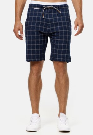 Shorts à carreaux bleu marine avec taille à cordon, présentant des lignes blanches et un tissu léger. Design à longueur de genou avec poches latérales.
