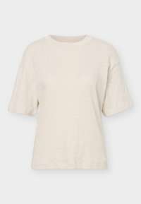 T-shirt crème à manches courtes avec col rond, coupe décontractée et tissu doux texturé.