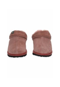 Pantofole in suede rosa con fodera in morbido pellicciotto, caratterizzate da un retro basso, suole in gomma nera e una suola esterna texturizzata di un marrone rossiccio.