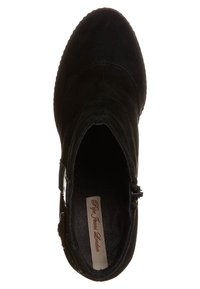 Czarne zamszowe botki za kostkę z okrągłym noskiem, bocznym zamkiem błyskawicznym i subtelnymi detalami w szwie. Wnętrze ma markową etykietę na beżowym tle.