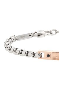 Pulsera de cadena de plata con un acento rectangular de oro rosa con un detalle texturizado y una gema negra. Marcada con la etiqueta "BREIL".