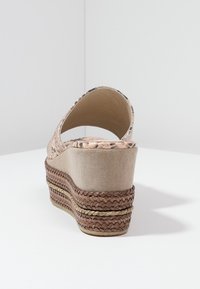 Beige kilklackssandal med flätad jute och textilövre del, rundad baksida och en lagerplattform med ett vävt mönster och kontrasterande detaljer.