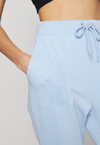 NA-KD PAMELA REIF x NA-KD - TRACKSUIT BOTTOMS - Calças de fato de treino - dusty blue