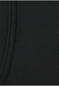 Black fabric, smooth texture with a slight sheen. Features a visible seam with contrasting stitching for design detail.