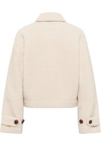 Cremefarbene Lammfelljacke mit kurzem Schnitt, klassischem Kragen und Knopfdetails an den Manschetten. Weicher, strukturierter Stoff.