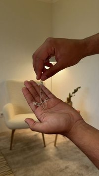 Sudraba kaklarota rokā, ar smalku ķēdīti un ziedu akcentiem, gludu tekstūru un elegantu cilpa aizdari.