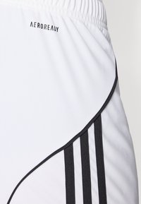 Calções atléticos brancos com uma cintura elástica preta, apresentando um design de faixa curva preta e três riscas verticais pretas de um lado.