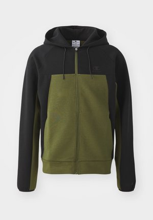 Sudadera con cremallera que presenta una parte superior negra y una parte inferior verde olivo, con un bolsillo tipo canguro y cordones en la capucha.