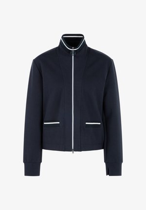 Navy zip-up jacket with a stand collar, white accents on the collar and pockets, and ribbed cuffs; features a smooth, textured fabric.