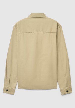 Camicia beige a maniche lunghe con colletto classico, balza posteriore e polsini con bottoni. Realizzata in tessuto di cotone liscio con una trama uniforme.