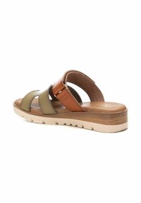 Sandalias de cuero marrón y oliva con tres correas, plantilla de corcho y una suela exterior de goma ligera en color beige con detalles texturizados.
