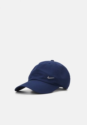 Gorra azul marino hecha de tela ligera con visera curvada, con un pequeño logo plateado de Nike en la parte frontal.