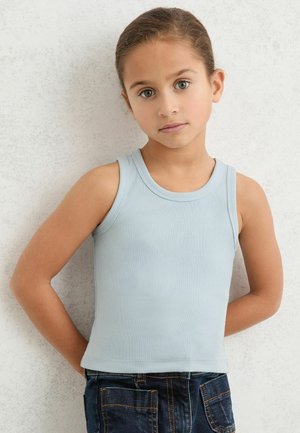 Maiou bleu deschis cu dungi, cu decolteu rotund, design cambrat și bretele pe umeri, combinat cu blugi din denim închis la culoare.