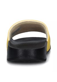 Sandalo slide nero e giallo con una fascia larga, lettino curvato e suola testurizzata. La vista posteriore mostra un materiale simile alla schiuma sul lato inferiore.