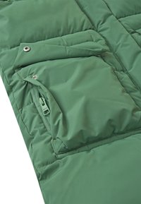 Grøn polstret jakke med en lynlåslomme og trykknaplukning. Blød tekstur og quiltet design med synlige sømdetaljer.