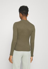 Oliivinvihreä ribbineulepaita pitkillä hihoilla ja aaltoilevalla pääntielle, jossa on joustava siluetti ja tekstuuri.