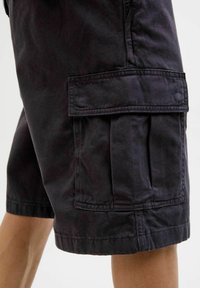 Pantaloni scurți cargo negri, fabricate dintr-un material durabil, având buzunare laterale mari, croială lejeră și tiv care se oprește deasupra genunchiului.
