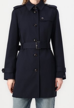 Marineblauwe trenchcoat van polyester met een ceintuur in de taille, knoopsluitingen, schouderstukken en lange mouwen. Voorzien van een kraag en zakken.
