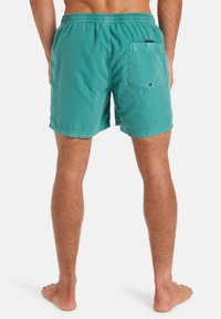 Turquoise plavky vyrobené z jemnej tkaniny. Obsahujú elastický pás a zadnú kapsu so zapínaním na gombík. Dĺžka do polovice stehna.