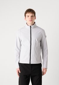 Ανοιχτό γκρι αδιάβροχο μπουφάν με ψηλό γιακά, μαύρο φερμουάρ και πλαινές τσέπες. Λείος υφασμάτινος σχεδιασμός με τακτοποιημένη γραμμή.