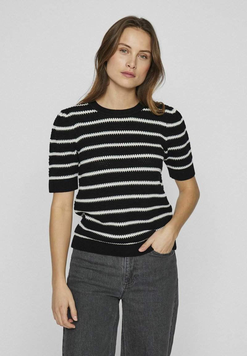 Suéter de punto a rayas blanco y negro con mangas cortas, cuello y dobladillo acanalados, con un acabado texturizado. Material suave, corte casual.