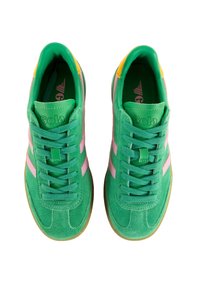 Zapatillas de ante verde con rayas rosas, suela de goma y cordones verdes. Presenta un acento amarillo en el talón y un logotipo en relieve.
