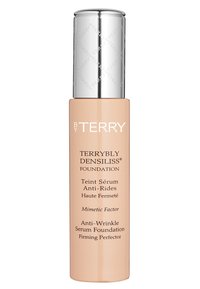 Fundamentflasche mit einem schlanken, zylindrischen Glasgehäuse, cremig beiger Farbe, silberner Metallkappe und weißen Text, der die Produktmerkmale beschreibt.