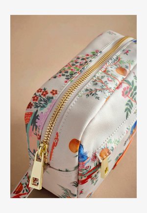Trousse de maquillage zippée avec un imprimé floral dans des couleurs variées sur un tissu clair, avec des finitions en or et une forme structurée.